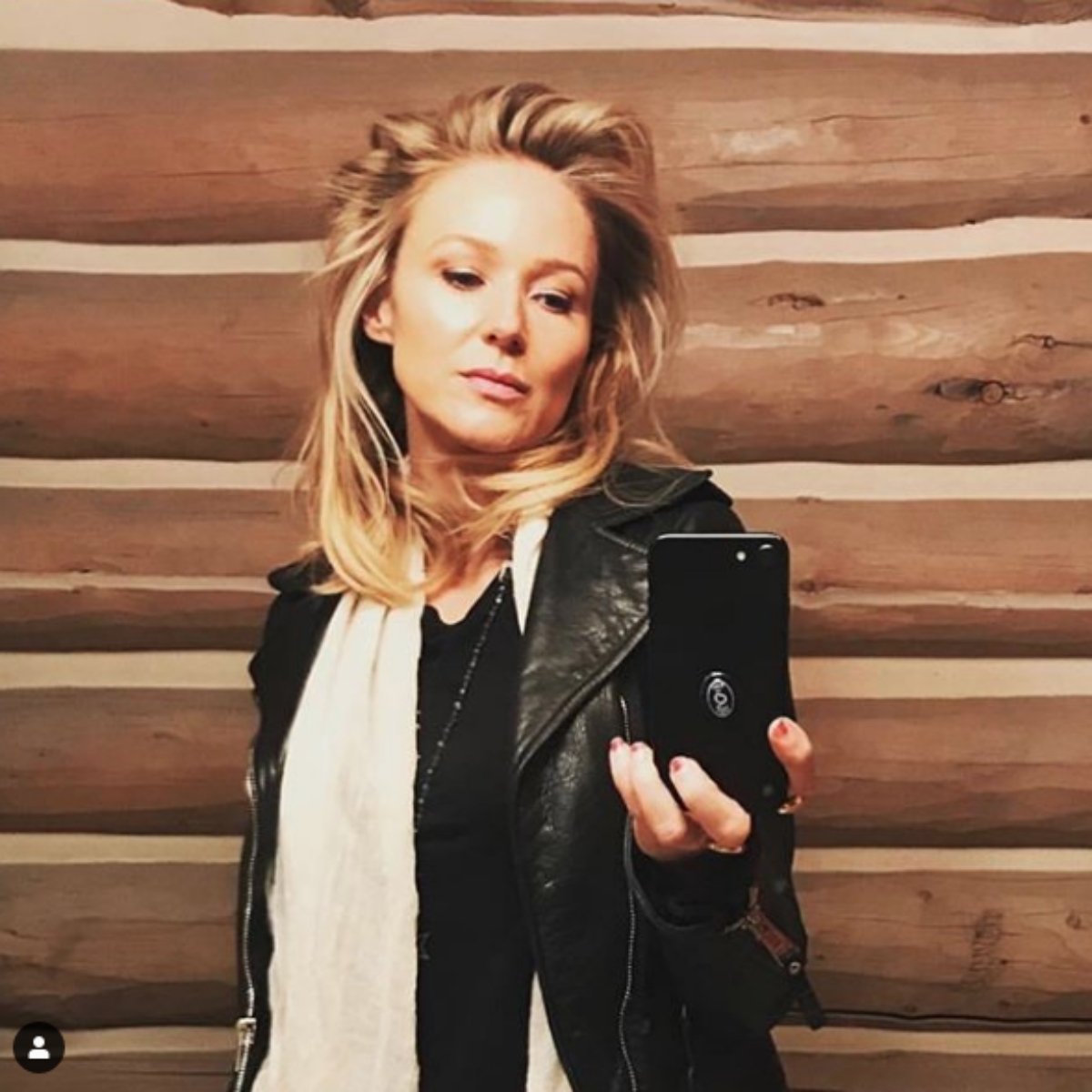 Singer Jewel's taking picture of new hair in mirror