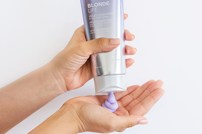 Blonde Life Violet Conditioner pouring into hand