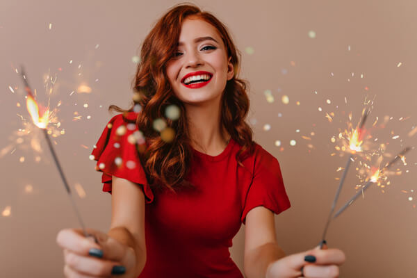 Holiday-Hair Women smiling with sparklers in hand