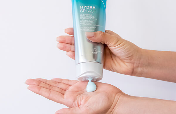HydraSplash-conditioner-in-hand Hair styling product being squuezed out of bottle