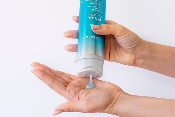 HydraSplash-shampoo-in-hand Hair styling product being squuezed out of bottle