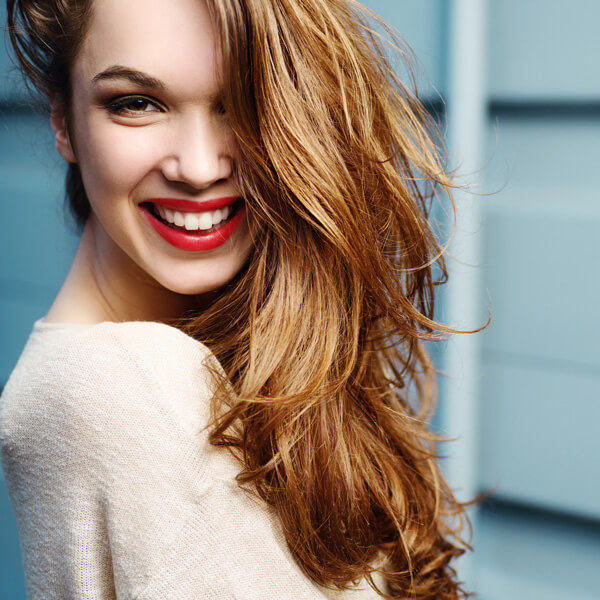 Textured-Holiday-Hair Model smiling with red hair