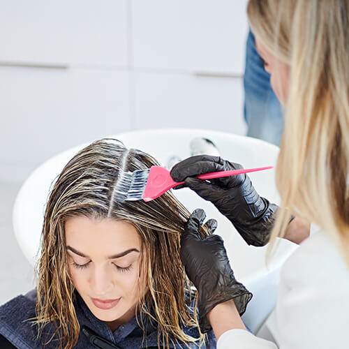 Women getting hair colored in salon