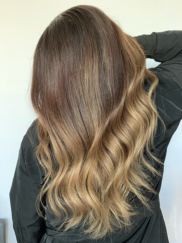 brunette woman turned around with soft curls in hair