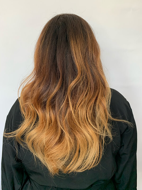 Red haired woman turned around with soft curls in hair