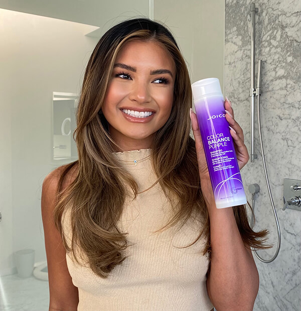 image00009 Woman smiling holding Joico color balance Purple shampoo
