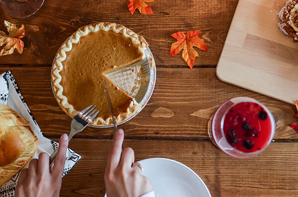 pumpkini-pie hands with knife and fork cutting into pumpkin pie
