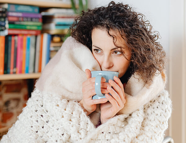woman in cozy blanket woman in cozy blanket drinking coffee