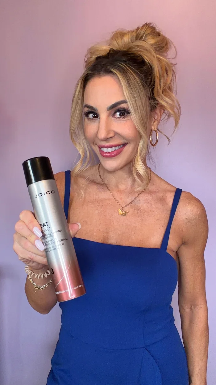 Vanessa Drozda with updo hair style holding Heat Hero bottle