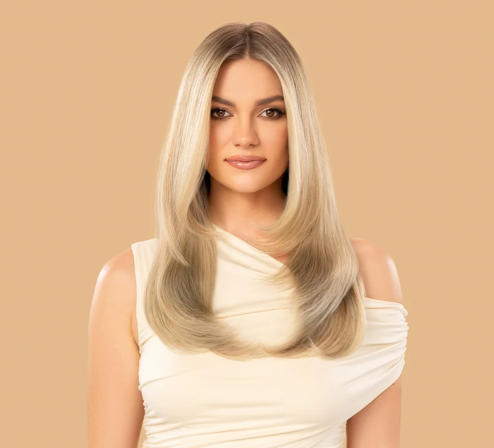 Woman with nicely colored hair standing in front of tan colored background