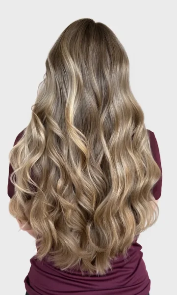 Woman with long curly and shiny highlighted hair